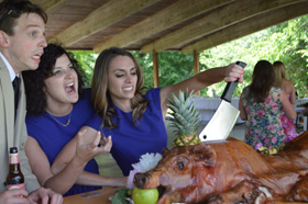 Three guests having fun with the pig
